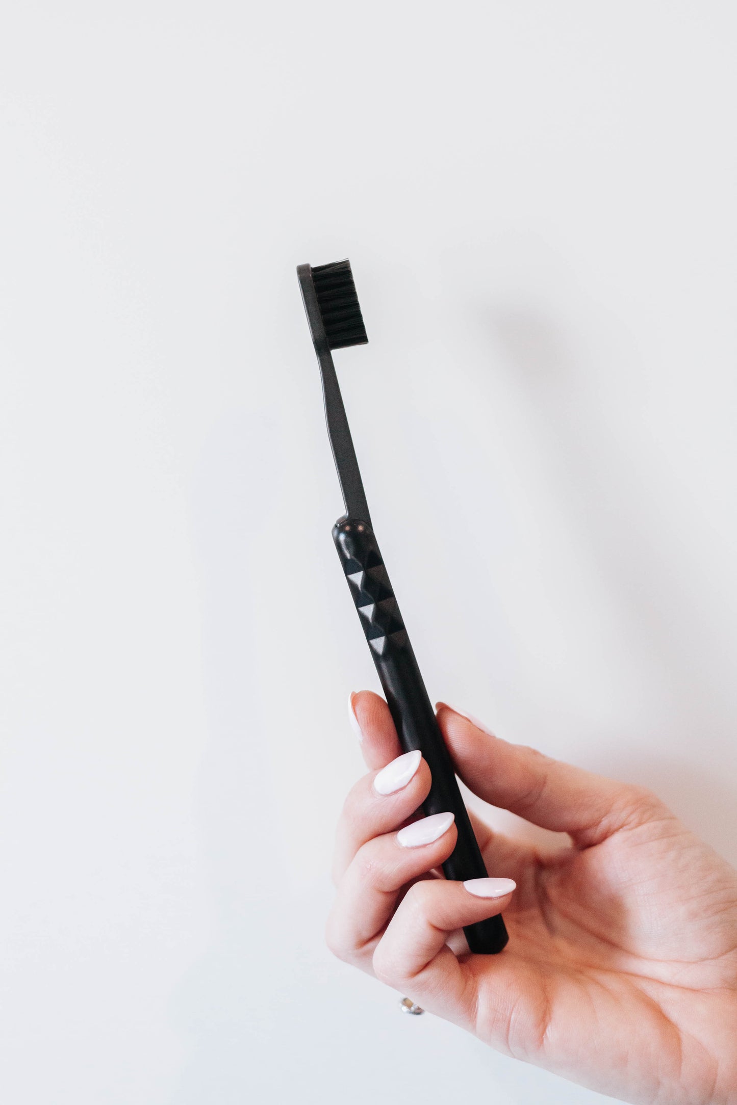 Starter Kit Black Aluminum Brush Handle and Biodegradable Brush presented in Hand