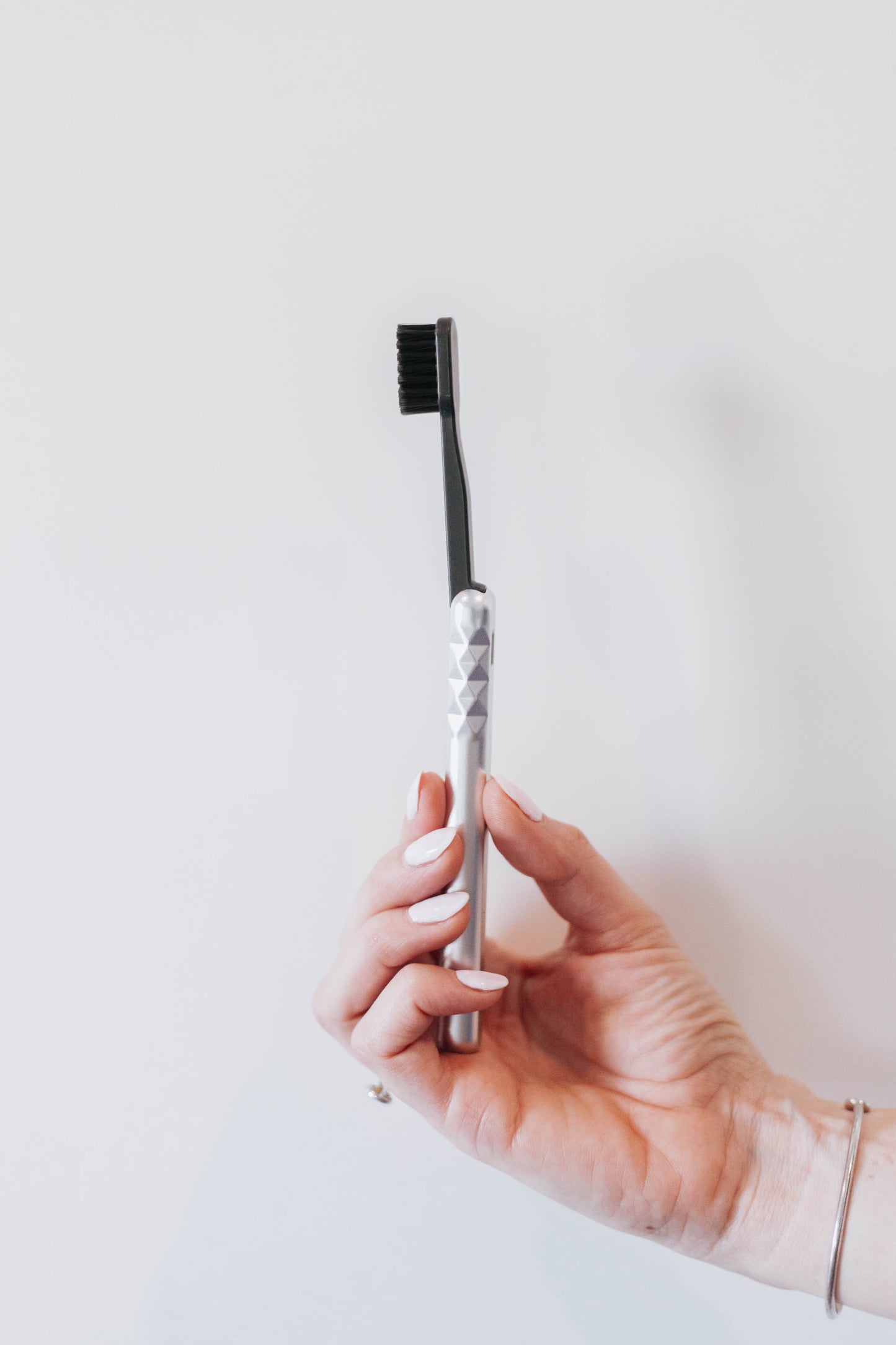 Starter Kit Silver Aluminum Brush Handle and Biodegradable Brush presented in Hand