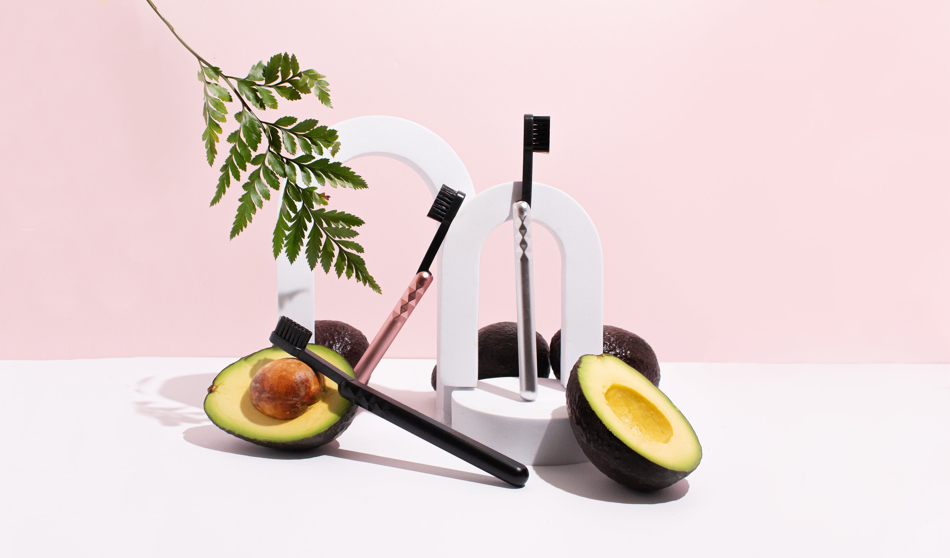 Aluminum Toothbrushes with Biodegradable Brush heads, Avocados surrounding three colour variations of this natural toothbrush